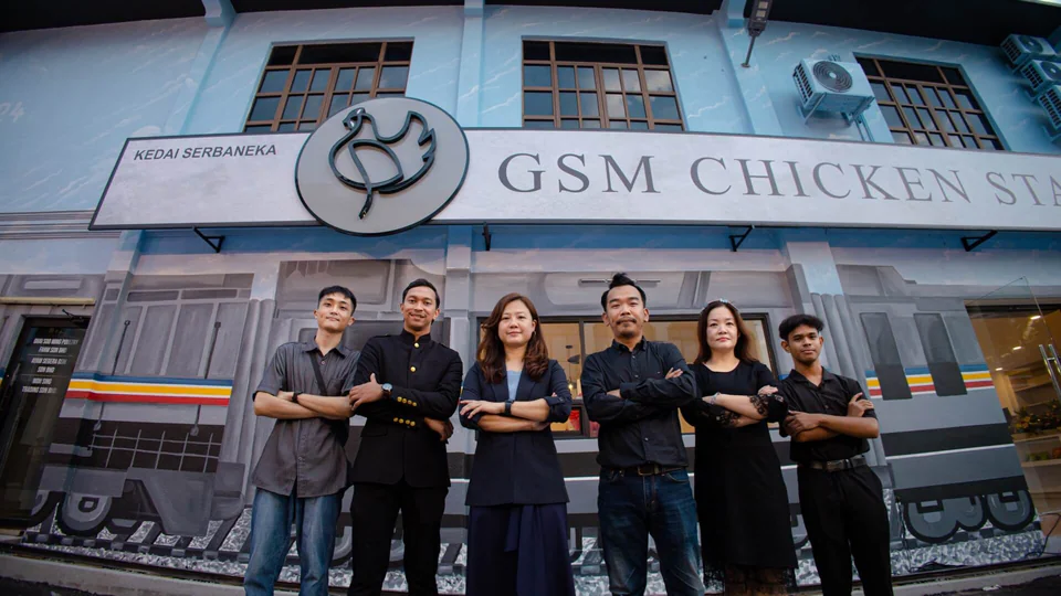 Pasukan GSM Chicken Station di hadapan kedai di Segamat