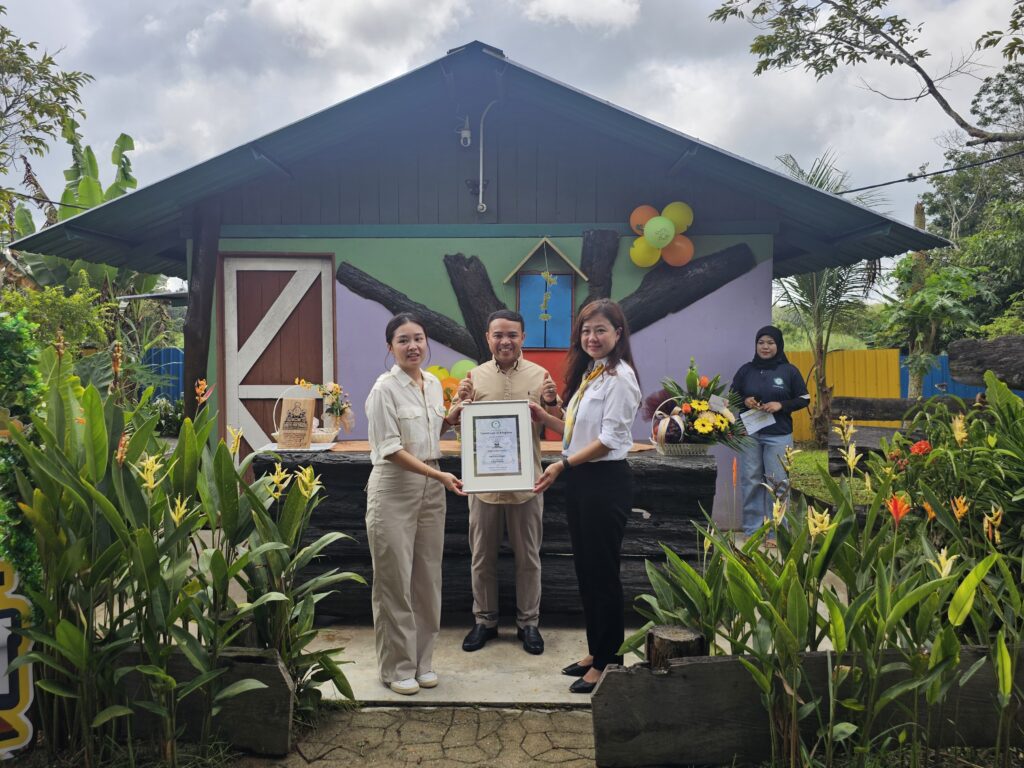 Walters Farm CEO Tey Jia Ying (left) presents the crocodile adoption certificate to GSM Chicken Station founder Ghai Swee Ling (right), witnessed by Segamat Municipal Council President Tuan Haji Mohd Helmi Bin Dato' Haji Sha'ri @ Shangari (center).